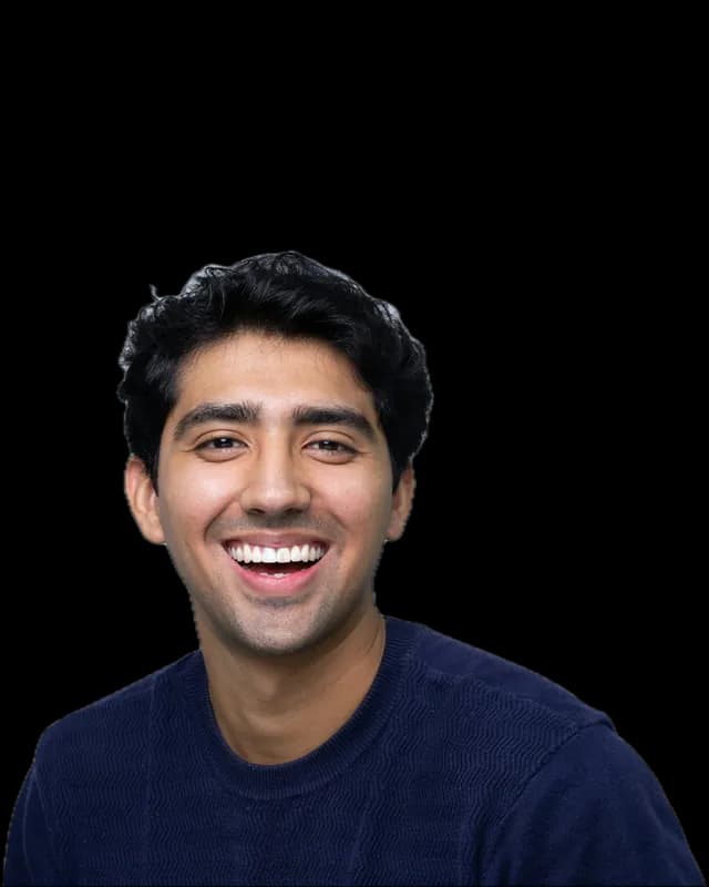 A young man in a navy sweater, laughing
